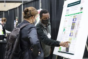 Erasmus Kabu Aduteye, graduate student at the University of Maryland Eastern Shore, discusses his research poster during the networking event at the end of Day One of the 2022 Delmarva Soil Summit on Monday, Feb. 7, in Salisbury, Md.